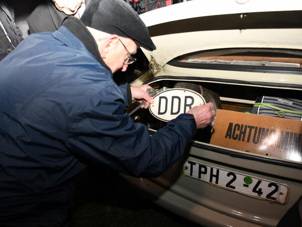 Bild vergr&ouml;&szlig;ern: Albrecht Gemeinhardt rollte als erster mit seinem Trabi �ber die B 173. Hier montiert er nochmal sein DDR-Schild an.
