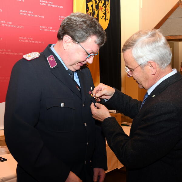 Bild vergr&ouml;&szlig;ern: Landrat Rolf Keil (rechts) w�rdigte den Kameraden Michael Mittag mit dem Feuerwehr- Ehrenzeichen als Steckkreuz in Silber.