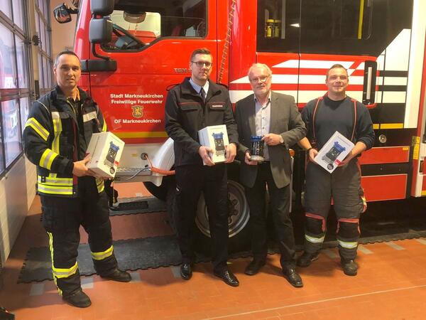 Bild vergr&ouml;&szlig;ern: Der Sachbearbeiter Bandschutz der Landkreisverwaltung Patrick Heinritz (2.von links) und der B&uuml;rgermeister der Stadt Markneukirchen Andreas Rubner (2.von rechts) &uuml;bergaben an die Feuerwehren Markneukirchen und Klingenthal die ersten Systemtrenner.