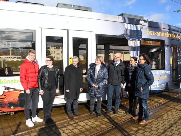 Bild vergr&ouml;&szlig;ern: Landrat Rolf Keil (3.von links) vor der neugestalteten Stra&szlig;enbahn im Gespr&auml;ch mit Studenten und weiteren Projekt-Beteiligten.