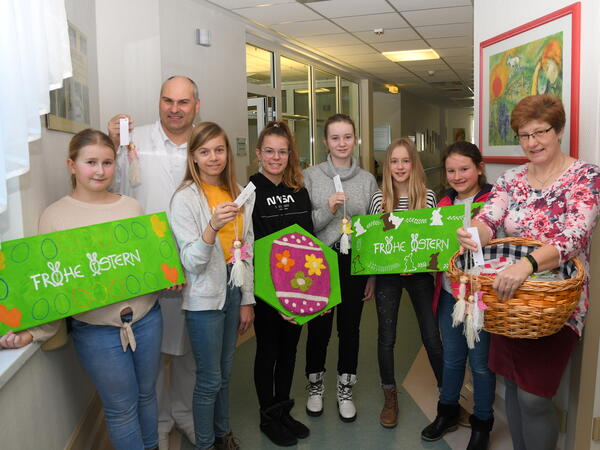 Bild vergr&ouml;&szlig;ern: Die Sch&uuml;lerinnen Tessa Sophia, Jade, Hannelene Martha, Sandrine, Luise, Natalie und Fachlehrerin Anke Graf  &uuml;bergaben die Schutzengel zusammen mit Osterbasteleien an den Chefarzt der Frauenklinik  Dr. Jiri Pomyje.