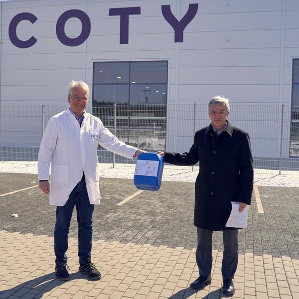 Bild vergr&ouml;&szlig;ern: Coty-Werkleiter  Ulrich J�hn (links) �bergibt an Landrat Rolf Keil  eine Spende von  Handdesinfektionsmitteln.