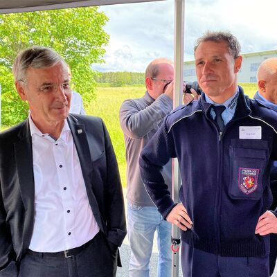 Bild vergr&ouml;&szlig;ern: Landrat Rolf Keil und Andy Kropf, der Gemeindewehrleiter der Feuerwehr Treuen stehen unter einem Zelt.