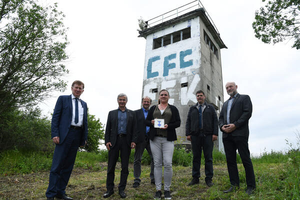 Bild vergr&ouml;&szlig;ern: Staatssekret&auml;r Dr. Frank Pfeil, Landrat Rolf Keil, Museumsleiter Robert Lebegern, Ortsvorsteherin Lisa Richter, B&uuml;rgermeister Steffen Raab und Landtagsabgeordneter Andreas Heinz (von links nach rechts) freuen sich, dass der Grenzturm erhalten und perspektivisch als Gedenkort genutzt werden soll.