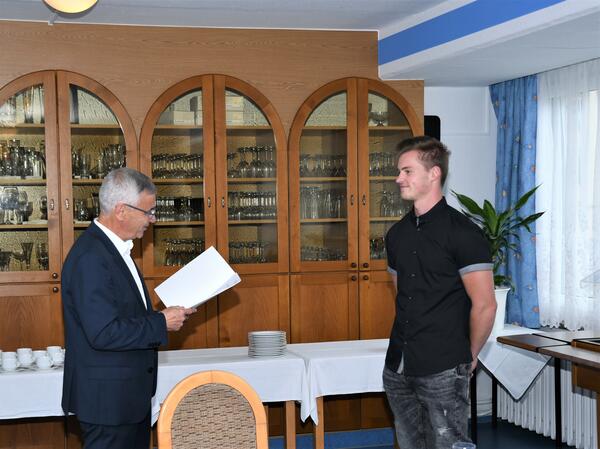 Bild vergr&ouml;&szlig;ern: Landrat Rolf Keil &uuml;berreicht Jimmy Bauer als bester Auszubildender seines Jahrgangs im Ausbildungsberuf &raquo;Stra&szlig;enw&auml;rter&laquo; in Sachsen sein Zeugnis