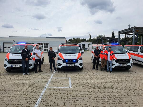 Bild vergr&ouml;&szlig;ern: Mitarbeitern der Johanniter Unfall-Hilfe e.V. des Regionalverbandes Zwickau/Vogtland, des DRK-Kreisverbandes Auerbach e.V. und des DRK Zentrums Plauen/Vogtland e.V. stehen vor den drei wei&szlig;-orangenen Einsatzfahrzeugen.
