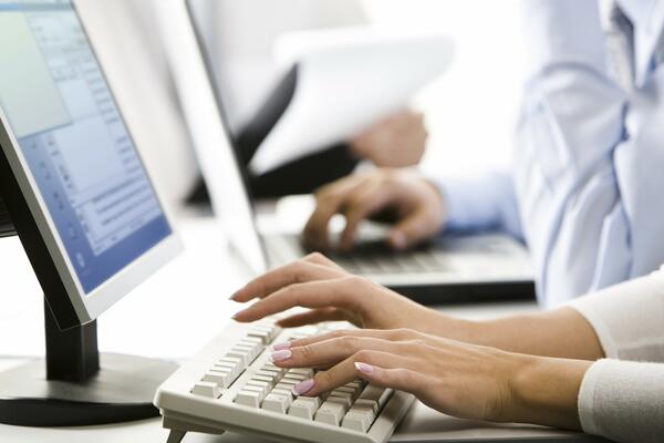 Bild vergr&ouml;&szlig;ern: Zu sehen ist, wie eine Frau und ein Mann an einem Computer schreiben.