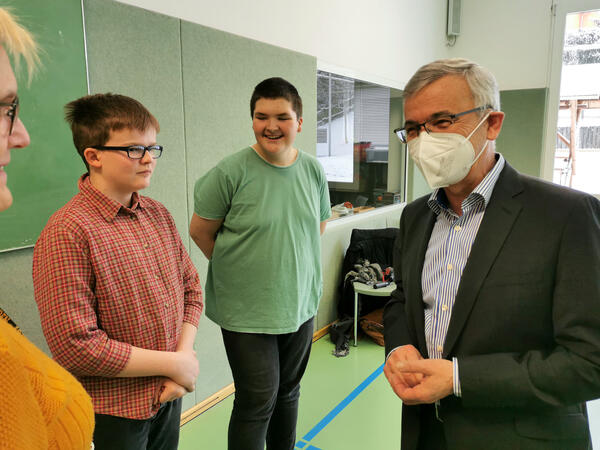 Bild vergr&ouml;&szlig;ern: Landrat Rolf Keil unterh�lt sich mit einer Lehrerin. Zwei Jungen stehen daneben und lachen.