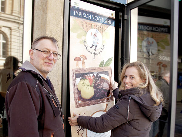 Bild vergr&ouml;&szlig;ern: Hausmeister Stefan Seiferth und Grafikerin Susann Schmidt beim Anbringen der neuen Ausstellungstafeln.