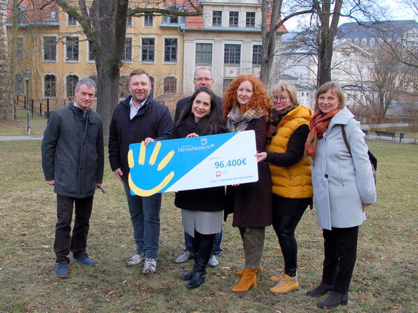 Bild vergr&ouml;&szlig;ern: Dr. Uwe Drechsel (Beigeordneter des Vogtlandkreises), Stephan Masch (Repr&auml;sentant der Deutschen Fernsehlotterie), Steffen Zenner (Oberb&uuml;rgermeister Stadt Plauen), Maria Cecilia Barrientos  (Projektkoordinatorin interkultureller Ideengarten), Anja Merkel (Projektkoordinatorin interkultureller Ideengarten), Christiane Ripp (Vorstandsvorsitzende Caritasverband Voigtland e.V.), Felicitas Munser (Gesch&auml;ftsf&uuml;hrerin Caritasverband Voigtland e.V.) (v.l.n.r.) bei der Scheck&uuml;bergabe.