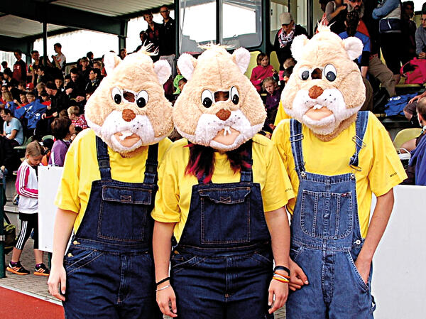 Bild vergr&ouml;&szlig;ern: Das Bild zeigt drei Personen verkleidet als Goldi-Goldhamster, der als Maskottchen fest die Daumen dr�ckt, wenn es darum geht Goldmedaillen zu gewinnen.