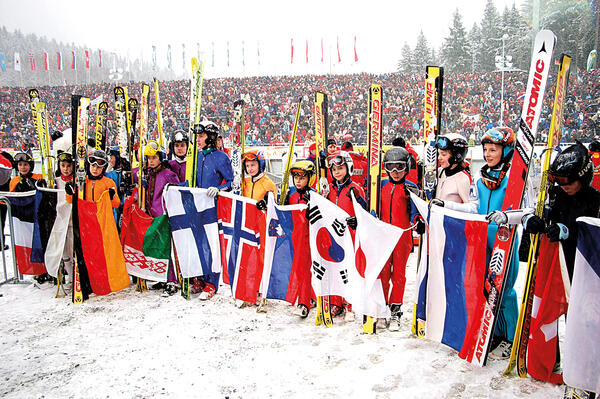 Bild vergr&ouml;&szlig;ern: Das Bild zeigt die Teinehmer eines Weltcups zum Skispringen in der Vogtland Arena Klingenthal aus verschiedenen L&auml;ndern mit ihren Landesflaggen.