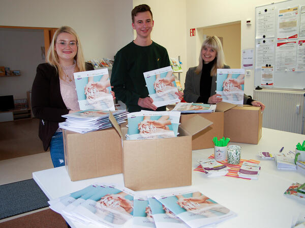 Bild vergr&ouml;&szlig;ern: Anne-Kathrin Kanis, Auszubildender Karl Michael und Sandy Haller (v.l.n.r.) beim kommissionieren der 5000 frisch gedruckten Vorsorgemappen auf den Weg in die St&auml;dte und Gemeinden des Vogtlandkreises.