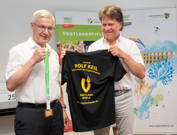 Bild vergr&ouml;&szlig;ern: Das Bild zeigt Landrat Rolf Keil und Steffen Fugmann, den Pr�sidenten des Kreissportbundes Vogtland e.V. bei der �bergabe des T-Shirts mit der Aufschrift "Rolf Keil, Schirmherr der Vogtlandspiele"