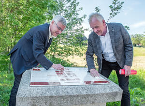 Bild vergr&ouml;&szlig;ern: Landrat Rolf Keil und der Europaabgeordnete Dr. Peter Jahr putzen die Tafel am Gedenkstein f&uuml;r Franz&ouml;sische Kriegsgefangene in Irfersgr&uuml;n