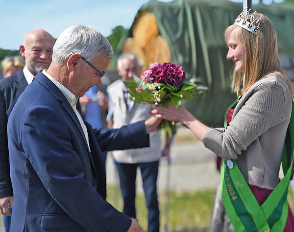 Bild vergr&ouml;&szlig;ern: Landrat Rolf Keil gratuliert der neuen s�chsischen Milchk�nigin Sandra Hartenstein und �berreicht ihr einen Blumenstrau�.