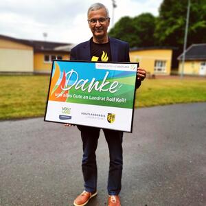 Bild vergr&ouml;&szlig;ern: Landrat Rolf Keil h&auml;lt ein Bild mit dem Wort "Danke" in die Kamera. Dieses hat er als Aufmerksamkeit vom Kreissportbund Vogtland e.V. erhalten.