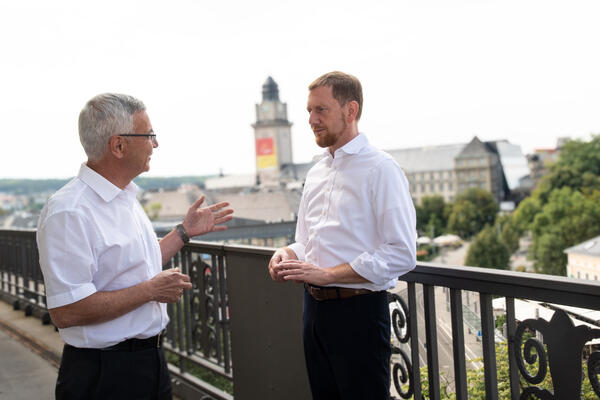 Bild vergr&ouml;&szlig;ern: Das Bild zeigt Landrat Rolf Keil und Ministerpr&auml;sident Michael Kretschmer. Beide stehen auf dem Balkon des Landratsamtes in Plauen. Im Hintergrund ist der Rathausturm in Plauen zu sehen.