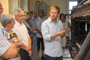 Bild vergr&ouml;&szlig;ern: Dr. Frank Luft vom Spitzenmuseum erkl&auml;rt die Wirkungseise einer Spitzenstickerei-Maschine.