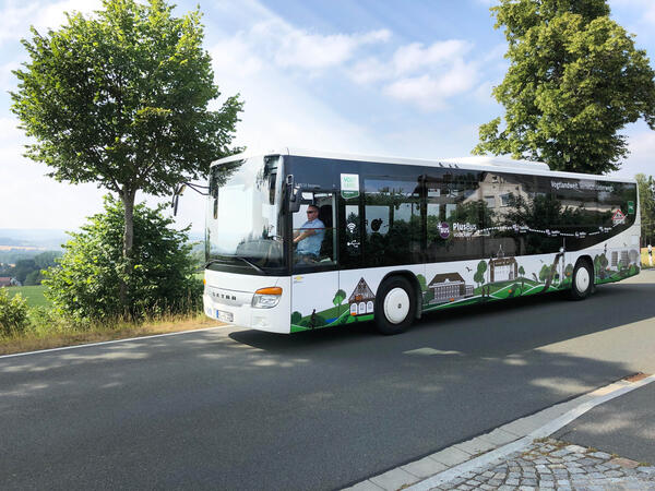 Bild vergr&ouml;&szlig;ern: Das Bild zeigt einen Bus, der bei sch�nem Wetter auf einer Stra�e f�hrt.