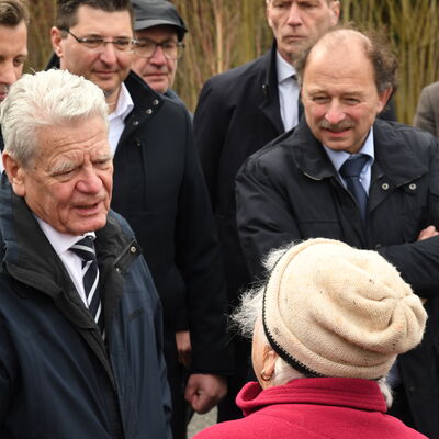 Bild vergr&ouml;&szlig;ern: Das Bild zeigt den Bundespr&auml;sidenten im Gespr&auml;ch mit einigen Anwohnern. Er zeigte sich sehr interessiert an deren Geschichten und Erlebnissen zur damaligen Zeit.