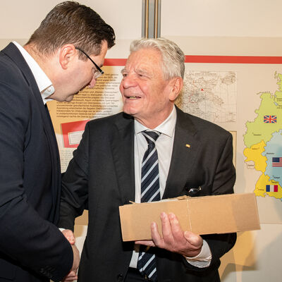 Bild vergr&ouml;&szlig;ern: Mit Gr&uuml;&szlig;en aus dem Vogtlandkreis: Landrat Thomas Hennig &uuml;bergibt dem ehemaligen Bundespr&auml;sidenten ein Genusspaket.