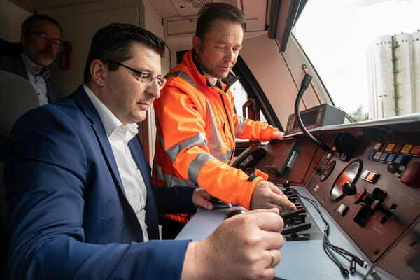 Bild vergr&ouml;&szlig;ern: Das Bild zeigt Landrat Thomas Hennig am Steuer eines Triebwagens der Vogtlandbahn. Triebfahrzeugf&uuml;hrer Steffen H&uuml;bner erkl&auml;rt ihm die Technik