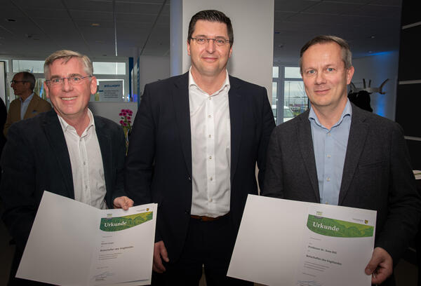 Bild vergr&ouml;&szlig;ern: Zwei neue Botschafter von Landrat Thomas Hennig berufen: Dietmar Karger von der Bad Brambacher Mineralquellen GmbH & Co. KG  und Prof. Dr. Sven Rill von der Fachhochschule Hof halten ihre Urkunden in die Kamera.