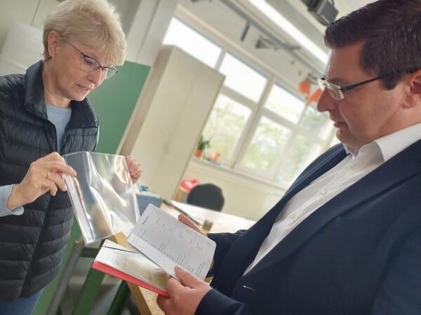 Bild vergr&ouml;&szlig;ern: Hausaufgabenhefte werden von Angestellten der Werkstatt in ihre H�llen gepackt