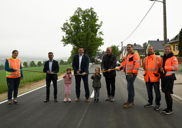 Bild vergr&ouml;&szlig;ern: Gemeinsam mit dem Landtagsabgeordneten S&ouml;ren Voigt (links) und dem B&uuml;rgermeister der Gemeinde Ellefeld, J&ouml;rg Kerber (rechts), gab Landrat Thomas Hennig (mitte) die Stra&szlig;e f&uuml;r den Verkehr wieder frei.