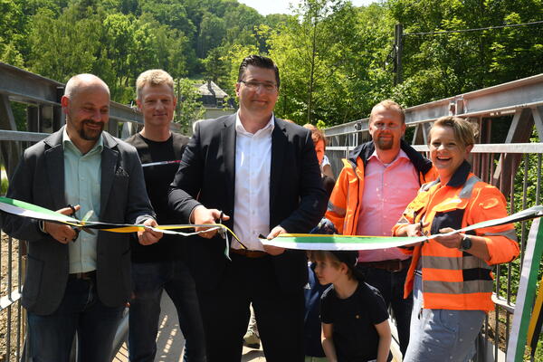 Bild vergr&ouml;&szlig;ern: P&ouml;hls B&uuml;rgermeister Erik Jung, Thomas Freundel von der UTR GmbH Sch&ouml;nbrunn, Landrat Thomas Hennig, Amtsleiter Alexander Maul und Eileen Zapf, Projektleiterin Stra&szlig;enbau beim Banddurchschnitt am Br&uuml;ckenprovisorium an der Barthm&uuml;hle.