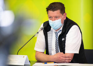 Bild vergr&ouml;&szlig;ern: Das Bild zeigt Jens Leistner, den Gesch&auml;ftsf&uuml;hrer des Rettungszweckverbandes S&uuml;dwestsachsen am Tisch sitzend, hiner einem Mikrofon mit einer Mund-Nasen-Bedeckung.