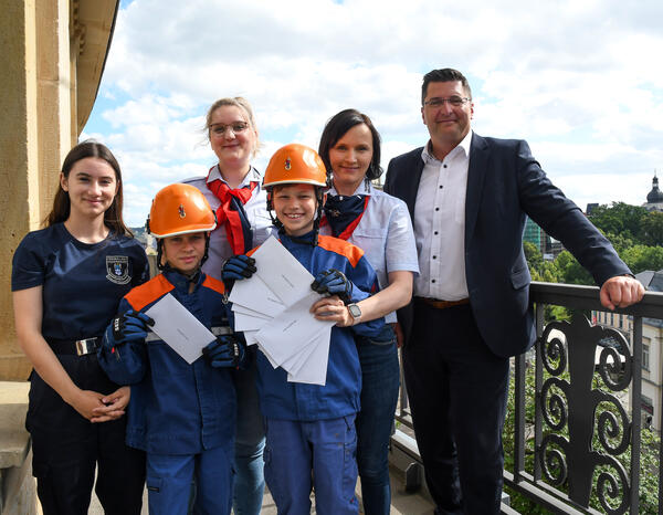 Bild vergr&ouml;&szlig;ern: Ren&eacute;e, Matteo und Max der Jugendfeuerwehr mit ihren beiden Kameradinnen der FFW Oberlauterbach Celine Hartmann und Nicole Petzoldt mit Landrat Thomas Hennig auf dem Balkon des Landratsamtes Vogtlandkreis