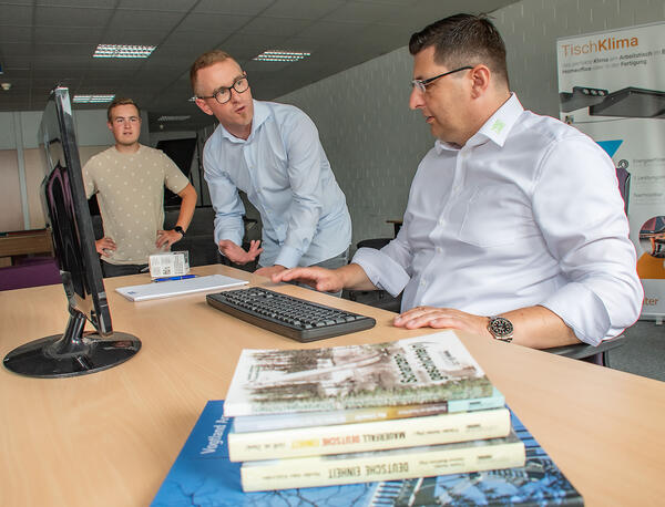 Bild vergr&ouml;&szlig;ern: David Seidel (Bildmitte) stellt dem Landrat den patentierten Schreibtisch aus dem Hause HOM vor.