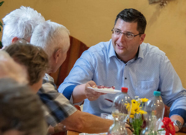 Bild vergr&ouml;&szlig;ern: Das Bild zeigt den Landrat Thomas Hennig beim Kaffeetrinken mit den Senioren