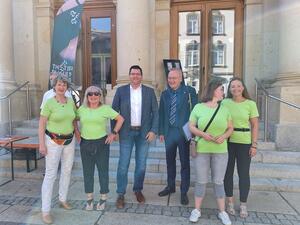 Bild vergr&ouml;&szlig;ern: Landrat Thomas Hennig und sein Beigeordneter Dr. Axel Steinbach mit den vier Frauen des Organisationsteams der Ehrenamtsmesse. Alle Frauen tragen hellgr&uuml;ne T-Shirts.