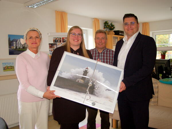 Bild vergr&ouml;&szlig;ern: Landrat Thomas Hennig (rechts) &uuml;bergibt einen Kunstdruck an Heike L&uuml;ckert, Gesellschafterin Luisa L&uuml;ckert und Gesellschafter Wolfgang L&uuml;ckert (von links nach rechts).