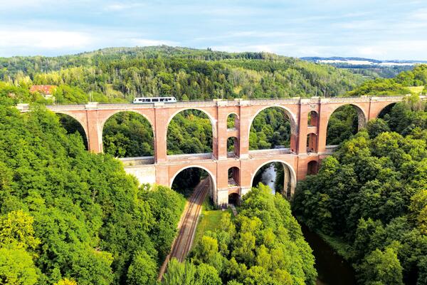 Bild vergr&ouml;&szlig;ern: Das Bild zeigt die Elstertalbr&uuml;ck im Vogtland auf der gerade ein Zug f&auml;hrt. Sie wird auch als kleine Schwester der G&ouml;ltzschtalbr&uuml;cke bezeichnet.
