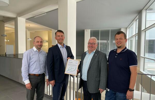 Bild vergr&ouml;&szlig;ern: Stefan Hanu&szlig;ek von der Firma DATEC und Matthias Ocken von der Firma KYOCERA &uuml;bergeben Uwe Lang, Amtsleiter des Amtes f&uuml;r Kataster und Geoinformation sowie Marco Rentler, dem Sachgebietsleiter Datenverarbeitung die Klimaschutzurkunde.