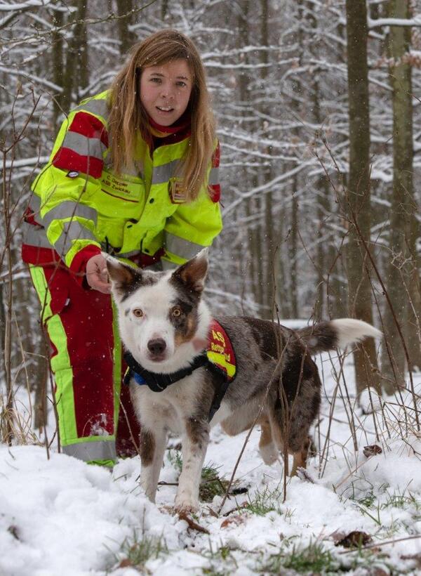 Bild vergr&ouml;&szlig;ern: Auf dem Bild sieht man Carola Deppler mit einem ihrer Rettungshunde beim Training im Winterwald