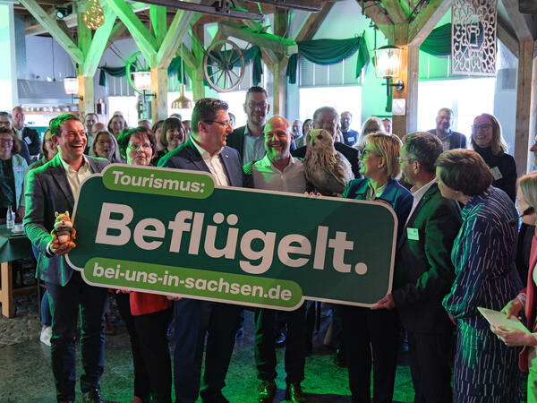 Bild vergr&ouml;&szlig;ern: Vertreter aus der Politik, darunter auch Landrat Thomas Hennig, halten ein gr�nes Schild, auf dem steht: Tourismus Befl�gelt.