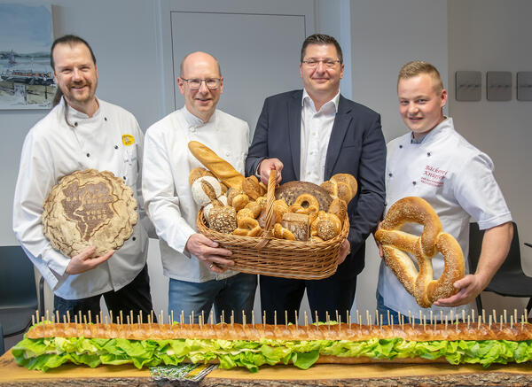 Bild vergr&ouml;&szlig;ern: B�ckermeister Torsten Aust, Obermeister J�rg Sch�rer und B�ckermeister Andre Kn�pfer (von links nach rechts) �bergeben an Landrat Thomas Hennig (2. von rechts) Brotpr�sente.