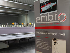 Bild vergr&ouml;&szlig;ern: Das Bild zeigt einen Aufsteller der embro GmbH. Sie suchen Produktionsmechanikerinnen und -mechaniker.