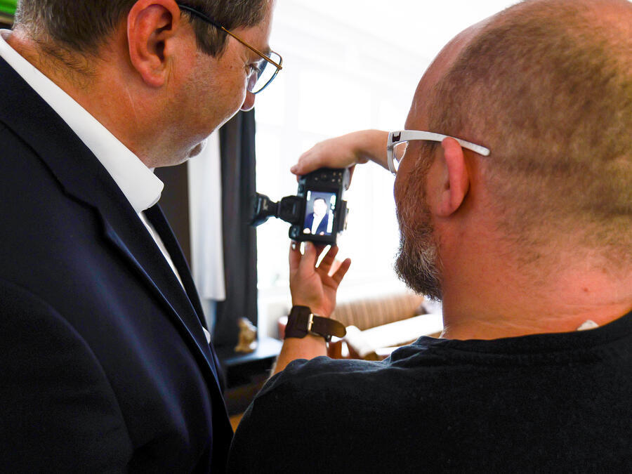 Fotograf Kenny Pool und Landrat Thomas Hennig sehen sich ein Foto an.
