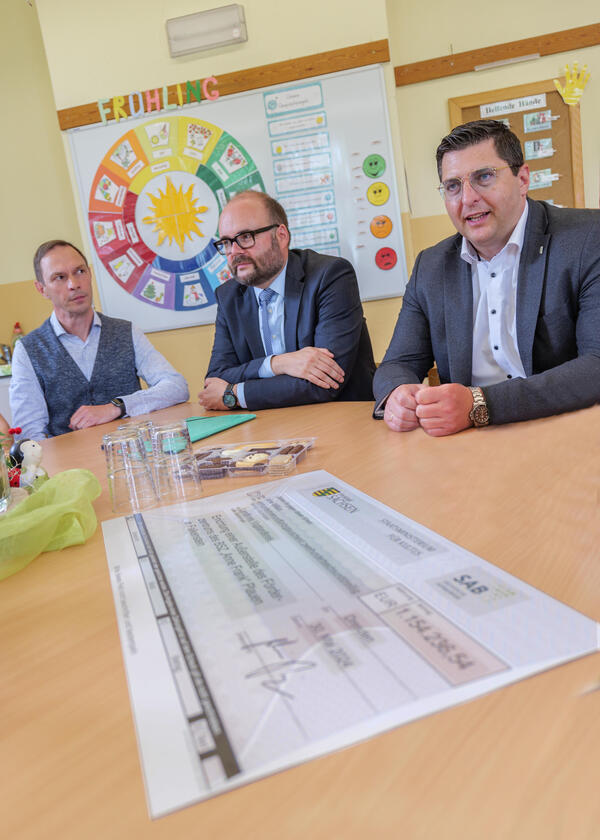 Bild vergr&ouml;&szlig;ern: Auf dem Bild sieht man drei Herren an einem Tisch sitzen.