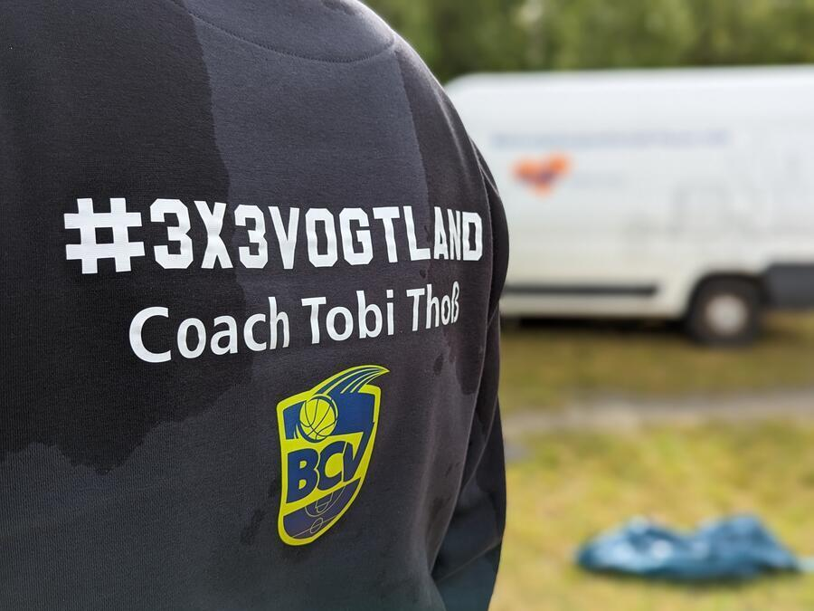 Ein schwarzer Pullover, auf dem #3x3Vogtland und Coach Tobi Tho&szlig; geschrieben stehen.