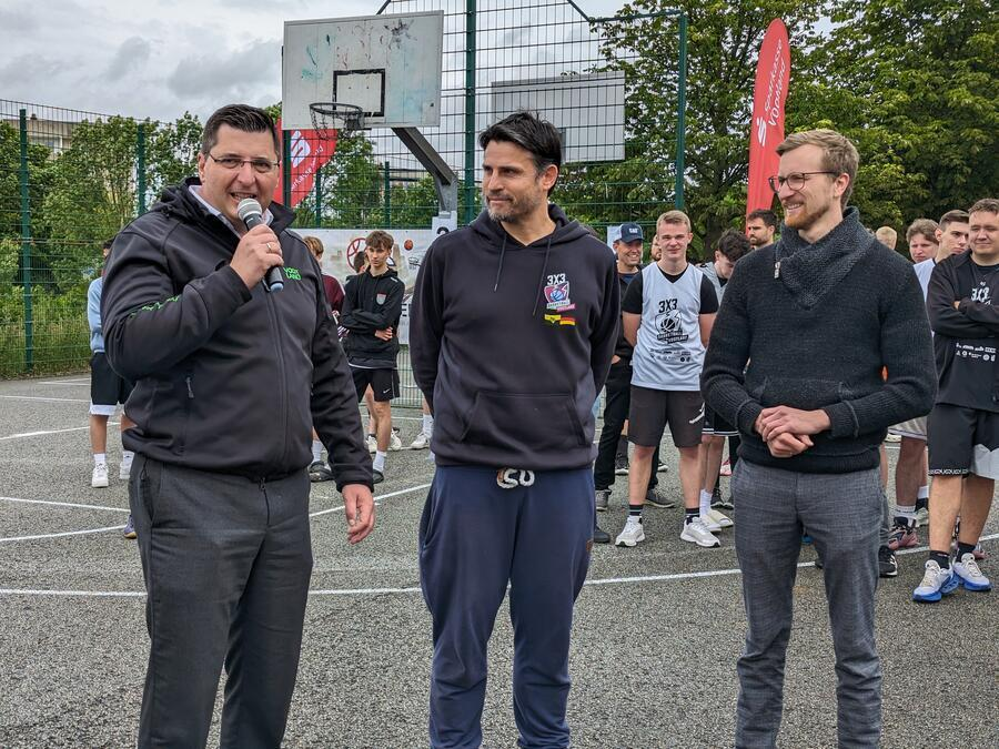 Landrat Thomas Hennig h&auml;lt ein Gru&szlig;wort mit einem Mikrofon. Neben ihm stehen Tobias Tho&szlig; und der Sozialb&uuml;rgermeister Plauens.