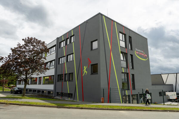 Bild vergr&ouml;&szlig;ern: Eine moderne Grundschule im Blockbau. Ihre Au�enw�nde sind mit roten und gr�nen Linien und Malereien verziert.