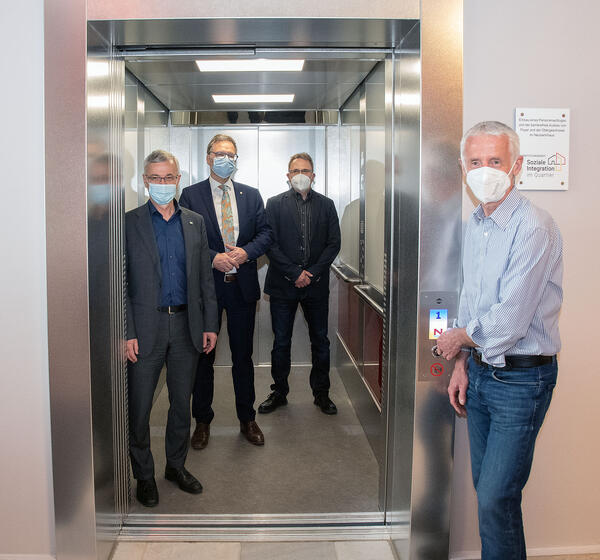 Bild vergr&ouml;&szlig;ern: Landrat Rolf Keil, der Oberb�rgermeister der Stadt Reichenbach, Raphael K�rzinger, der Leiter der Einrichtung Ronald B�hm und Christoph Fl�mig, Projektleiter Hochbau des Landratsamtes Vogtlandkreis stehen in und vor dem neuen Fahrstuhl im Neuberinhaus  der Stadt Reichenbach. Dieses ist jetzt barrierefrei auch f�r Menschen mit Einschr�nkungen frei erreichbar.