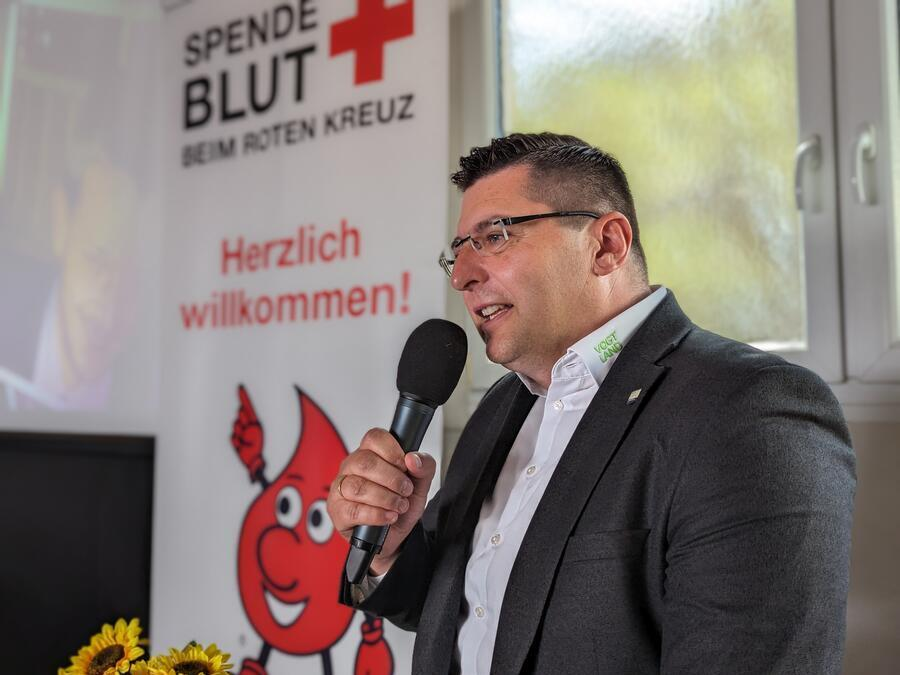 Landrat Thomas Hennig h&auml;lt eine Rede, das Mikrofon in der Hand.